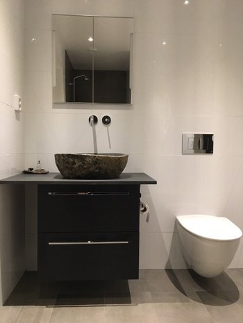 kundbild på stenhandfat köpt från unikstil. Modernt badrum med vitt kakel och svart kommod. 